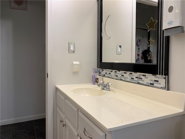 bathroom with tile patterned floors, baseboards, decorative backsplash, and vanity