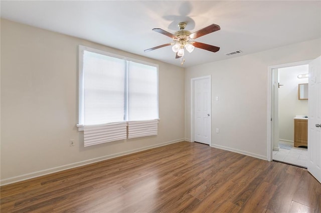 empty room with dark hardwood / wood-style floors and ceiling fan