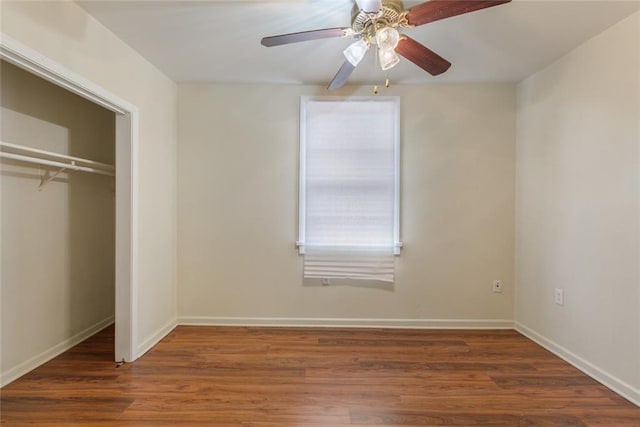 unfurnished bedroom featuring dark wood-type flooring, ceiling fan, and a closet