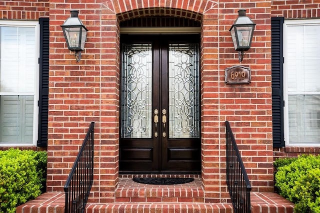 doorway to property featuring brick siding and french doors