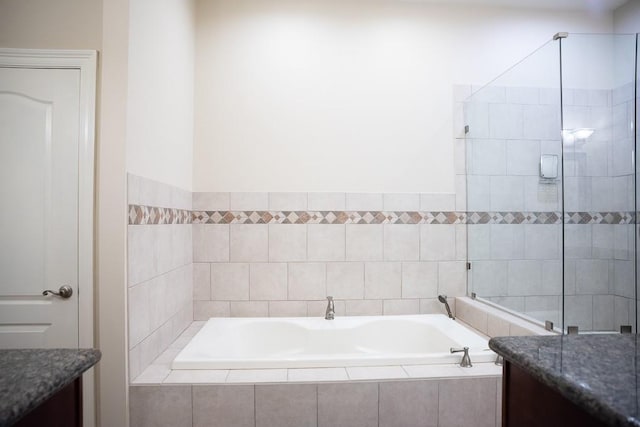 full bathroom with a stall shower, a bath, and vanity