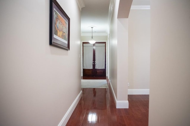 hallway with crown molding, baseboards, and wood-type flooring