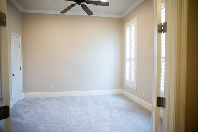 carpeted spare room with a wealth of natural light, baseboards, crown molding, and ceiling fan