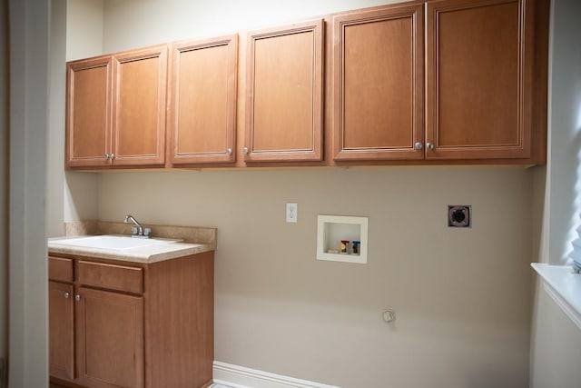 clothes washing area with washer hookup, a sink, hookup for a gas dryer, cabinet space, and hookup for an electric dryer