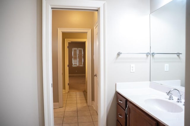 bathroom with tile patterned floors, baseboards, and vanity