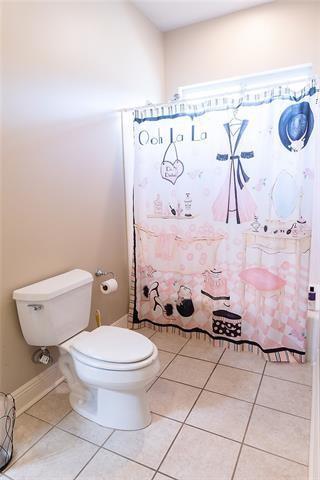 full bathroom with tile patterned flooring, curtained shower, and toilet