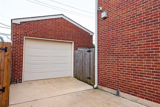 garage featuring concrete driveway and fence