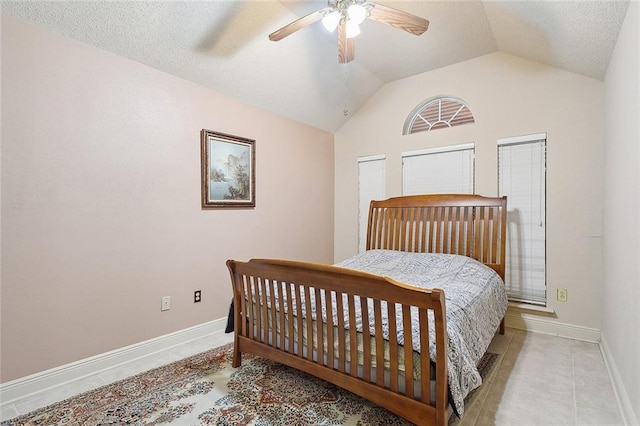 bedroom with lofted ceiling, light tile patterned floors, a ceiling fan, and baseboards