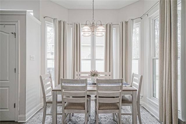 dining room featuring a chandelier and baseboards