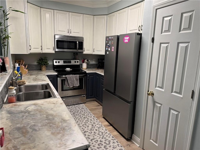 kitchen with white cabinetry, sink, stainless steel appliances, and light wood-type flooring