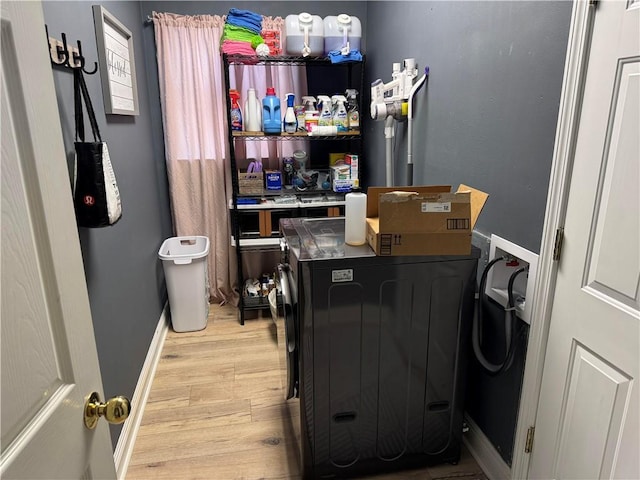 clothes washing area featuring washing machine and dryer and light wood-type flooring