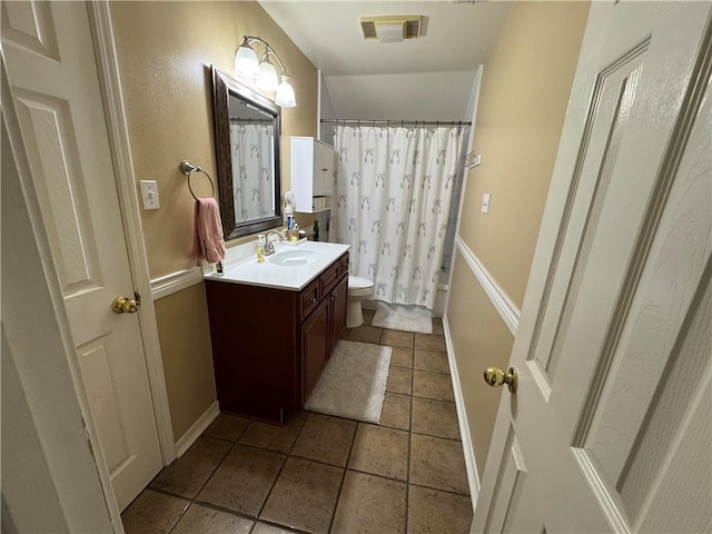 full bathroom with tile patterned flooring, vanity, shower / tub combo with curtain, and toilet