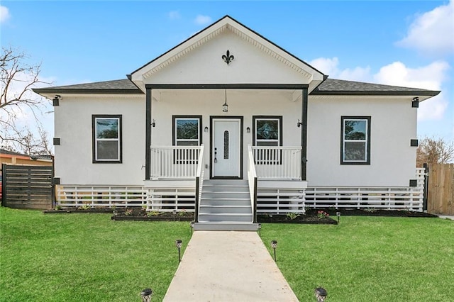 bungalow-style home with a shingled roof, fence, a front lawn, and a porch