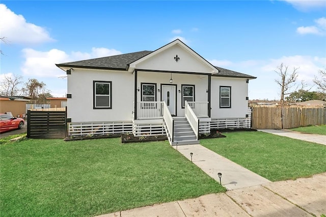 bungalow with covered porch, a front yard, and fence