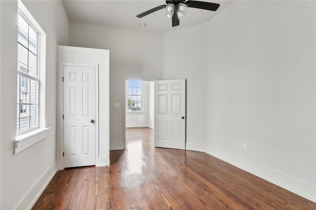 unfurnished bedroom featuring ceiling fan and dark hardwood / wood-style flooring