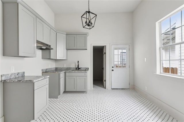 kitchen with pendant lighting, sink, a notable chandelier, and gray cabinets