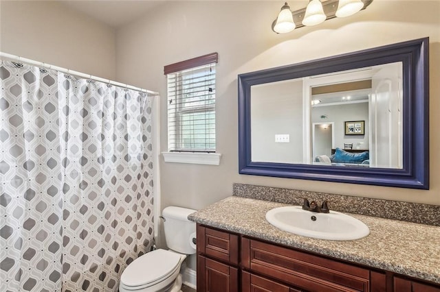 bathroom with vanity, curtained shower, and toilet