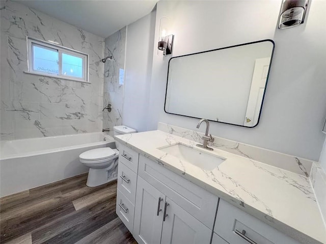 bathroom featuring vanity, shower / washtub combination, wood finished floors, and toilet