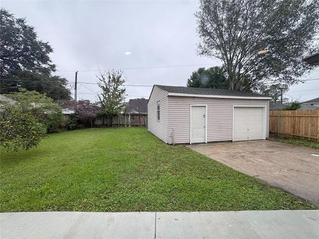 exterior space with concrete driveway, an outdoor structure, fence, and a detached garage