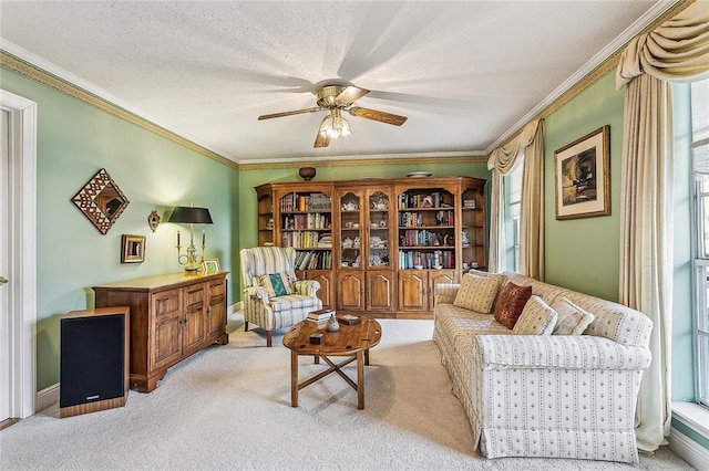 sitting room with light colored carpet, ornamental molding, and ceiling fan