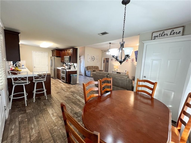 dining area featuring dark hardwood / wood-style flooring and a chandelier