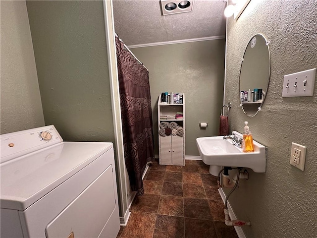 bathroom with washer / clothes dryer, sink, and a textured ceiling