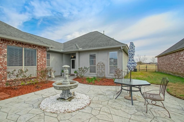 back of house featuring a patio area and a lawn