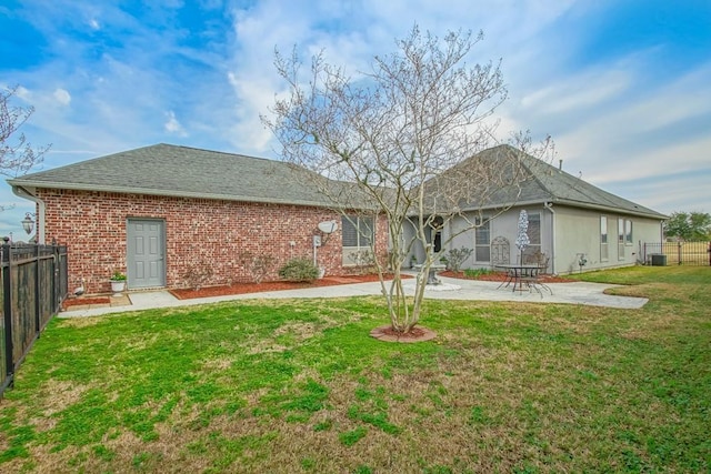 back of house with cooling unit, a yard, and a patio