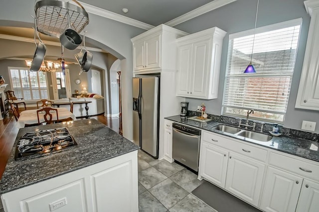 kitchen with sink, decorative light fixtures, ornamental molding, appliances with stainless steel finishes, and white cabinets