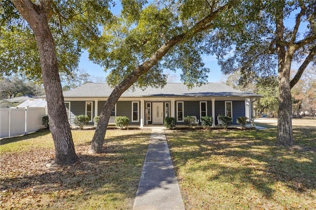 ranch-style home featuring a porch, a front yard, and fence