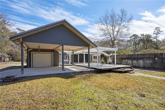 rear view of house with a garage, a pergola, fence, a yard, and a carport