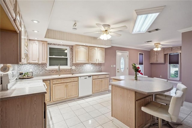 kitchen featuring range, light brown cabinets, dishwasher, and a sink