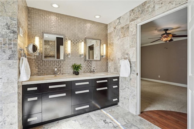 bathroom featuring ceiling fan, a sink, tile walls, and double vanity