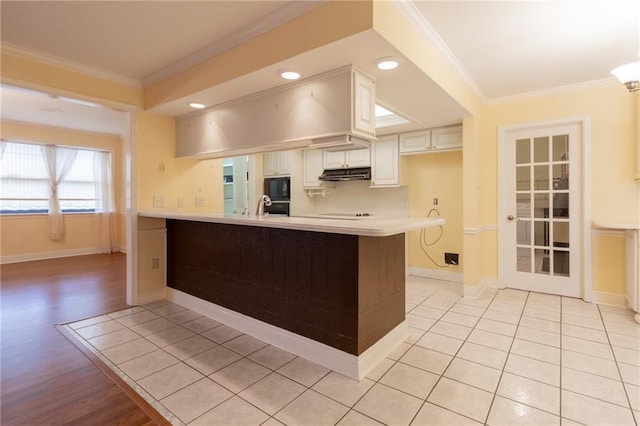 kitchen with white cabinetry, crown molding, kitchen peninsula, and black appliances