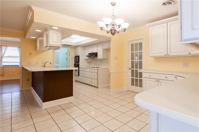 kitchen with white cabinetry, hanging light fixtures, crown molding, and sink