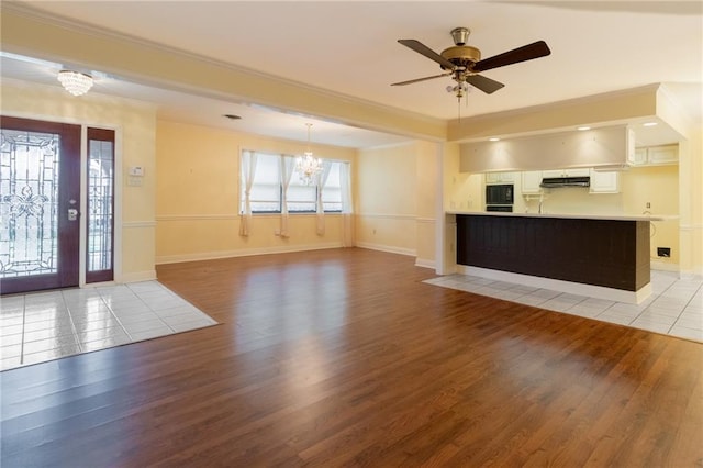 interior space with crown molding, ceiling fan with notable chandelier, and light hardwood / wood-style floors