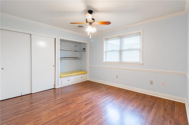 unfurnished bedroom with crown molding, dark wood-type flooring, and ceiling fan