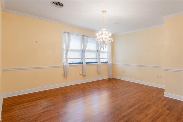 unfurnished room with hardwood / wood-style flooring, ornamental molding, and a chandelier