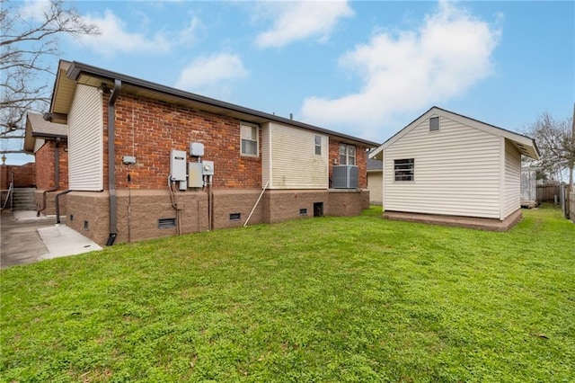 back of property featuring central AC and a yard