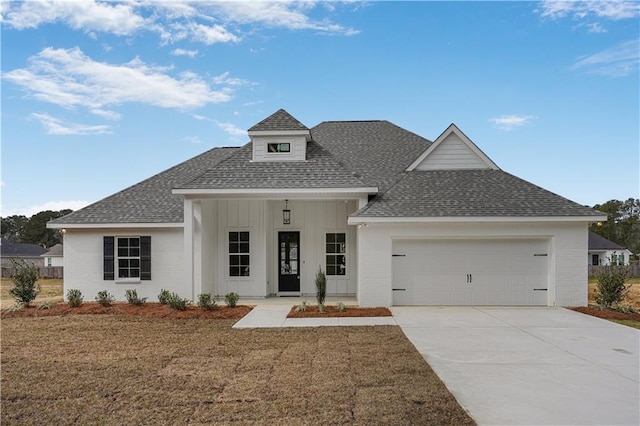 view of front of property featuring a garage, a front lawn, and covered porch