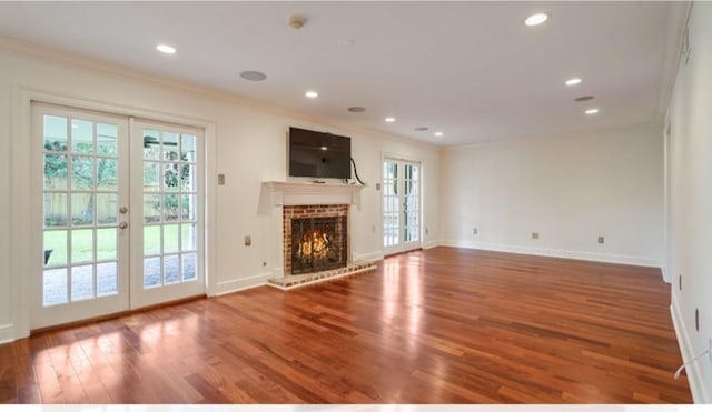 unfurnished living room featuring french doors, crown molding, and hardwood / wood-style floors