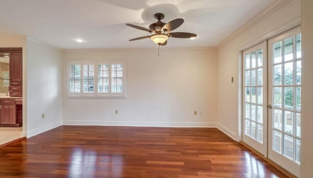 spare room featuring dark wood-type flooring, ceiling fan, and ornamental molding