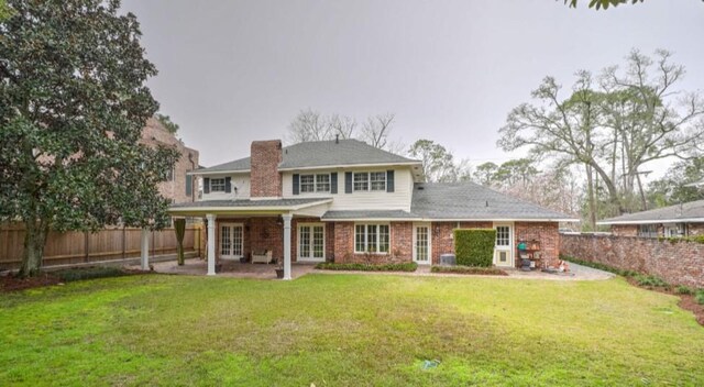 rear view of property with a lawn and a patio area