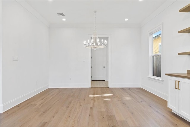 unfurnished dining area with crown molding, an inviting chandelier, and light hardwood / wood-style flooring