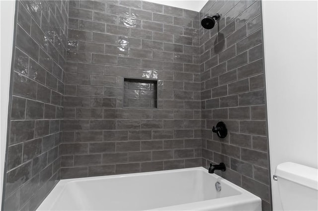 bathroom with tiled shower / bath and toilet