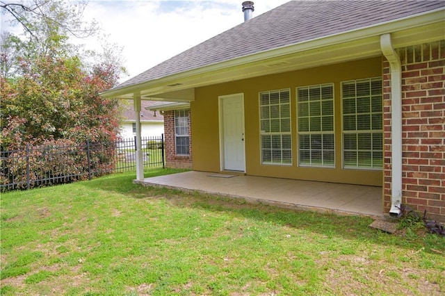 back of house with a patio area and a lawn