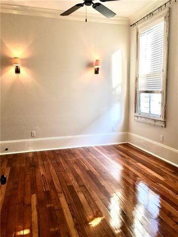 empty room with ornamental molding, dark wood-type flooring, and ceiling fan