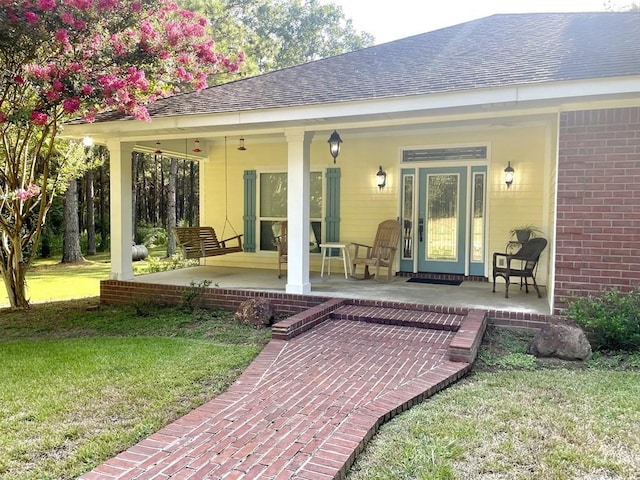 back of property featuring a porch and a yard