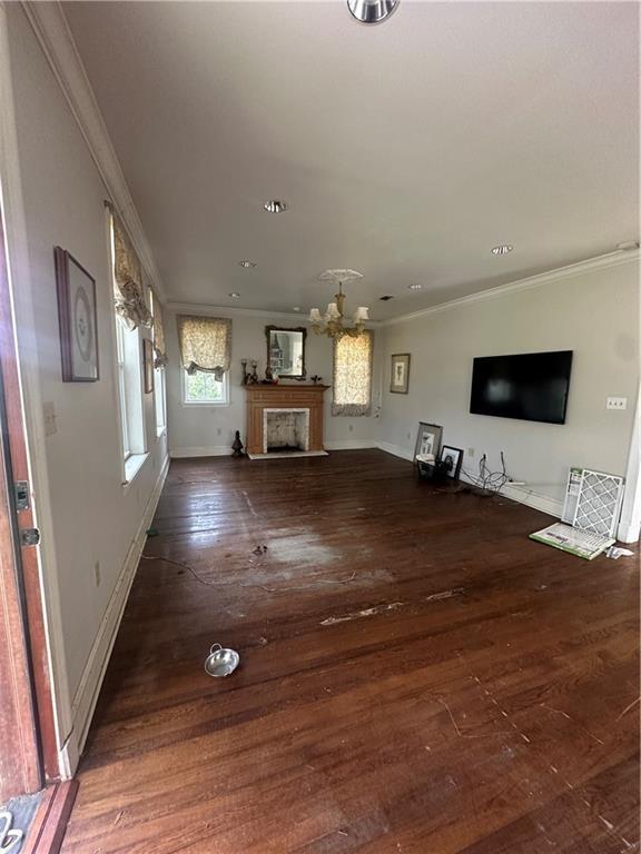 unfurnished living room with crown molding and dark hardwood / wood-style floors