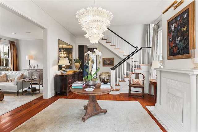 entryway with crown molding, hardwood / wood-style floors, and a chandelier